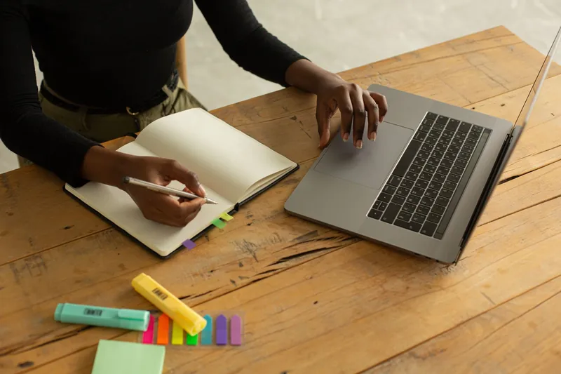 Carnet et ordinateur sur un bureau, photographie illustrative
